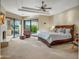 Large main bedroom with outdoor access, a decorative fireplace, and comfortable seating area with natural light at 9878 N 79Th Pl, Scottsdale, AZ 85258