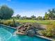 Beautiful pool featuring a rock waterfall, lush landscaping, and golf course views at 9878 N 79Th Pl, Scottsdale, AZ 85258