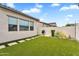 Well-maintained backyard with green lawn, barbecue grill, and neat landscaping, perfect for outdoor gatherings at 10006 E Rotation Dr, Mesa, AZ 85212