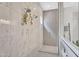 Modern bathroom shower featuring marble-like walls, dual shower heads, and herringbone-patterned tile accent wall at 10006 E Rotation Dr, Mesa, AZ 85212