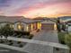 Charming home exterior with a well-manicured front yard, driveway, and warm lighting, creating a welcoming ambiance at 10006 E Rotation Dr, Mesa, AZ 85212