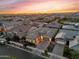 Stunning aerial view of a well-maintained home with a gray roof in a vibrant neighborhood at sunset at 10006 E Rotation Dr, Mesa, AZ 85212