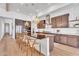 Open-concept kitchen with island seating, stainless steel appliances, custom cabinets, and stylish pendant lighting at 10006 E Rotation Dr, Mesa, AZ 85212