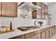 Close up of modern gas range with pot filler faucet, custom cabinets, white subway tile backsplash, and quartz countertop at 10006 E Rotation Dr, Mesa, AZ 85212