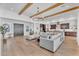 Spacious living room featuring hardwood floors, wood beam ceiling accents and open access to kitchen at 10006 E Rotation Dr, Mesa, AZ 85212