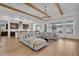 Bright living room with hardwood floors, exposed wood beams, modern chandelier, and an oversized sectional sofa at 10006 E Rotation Dr, Mesa, AZ 85212