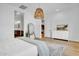 Bright main bedroom featuring a large mirror, modern accents and ensuite bath at 10006 E Rotation Dr, Mesa, AZ 85212