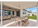 Spacious covered patio featuring a dining table, outdoor seating, and serene views of the well-maintained backyard at 10006 E Rotation Dr, Mesa, AZ 85212