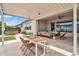 Relaxing outdoor patio area with dining table, seating, and views of the hot tub and beautifully landscaped yard at 10006 E Rotation Dr, Mesa, AZ 85212