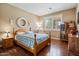 Bedroom features a wood bed frame, wood floors, and natural light from the window at 11025 E Nichols Ave, Mesa, AZ 85209