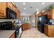 This kitchen boasts tile floors, wooden cabinets, and a black appliance package at 11025 E Nichols Ave, Mesa, AZ 85209