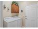 Bright laundry room features an overhead storage cabinet and white washer and dryer at 11025 E Nichols Ave, Mesa, AZ 85209