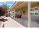 Covered brick patio with ample seating overlooks landscaping, featuring palm trees and greenery at 11025 E Nichols Ave, Mesa, AZ 85209