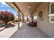 Covered brick patio with ample seating is surrounded by lush landscaping at 11025 E Nichols Ave, Mesa, AZ 85209