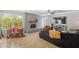 Bright living room with hardwood floors, brick fireplace, large windows, and a ceiling fan at 12639 N 47Th Ave, Glendale, AZ 85304