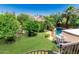 Expansive backyard with green lawn, mature trees, and a refreshing pool, creating an ideal outdoor retreat at 12837 N 68Th St, Scottsdale, AZ 85254