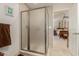 Bathroom featuring a glass shower, neutral tile and a view into an adjacent bedroom at 12837 N 68Th St, Scottsdale, AZ 85254