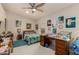Bedroom with ceiling fan, window and a desk piled with projects at 12837 N 68Th St, Scottsdale, AZ 85254