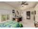 Bedroom with ceiling fan, window, closet and desk covered with projects at 12837 N 68Th St, Scottsdale, AZ 85254