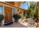 Inviting courtyard featuring a wooden door, potted plants, and cozy seating for relaxing outdoors at 12837 N 68Th St, Scottsdale, AZ 85254