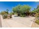 Scenic driveway leading to a home with mature trees and desert landscaping, offering serene curb appeal at 12837 N 68Th St, Scottsdale, AZ 85254