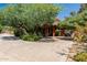 Beautiful home with a circular driveway, mature trees, and lush desert landscaping for added privacy at 12837 N 68Th St, Scottsdale, AZ 85254