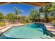 Sparkling pool with blue tiled trim and clear water, surrounded by lush landscaping and mature trees at 12837 N 68Th St, Scottsdale, AZ 85254