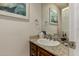Powder room with a granite countertop and framed swan art above the toilet paper holder at 12837 N 68Th St, Scottsdale, AZ 85254