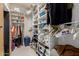 White shelving in walk-in closet filled with clothes, folded items and boxed items at 12837 N 68Th St, Scottsdale, AZ 85254