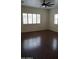 Sunlit bedroom with plantation shutters and dark wood floors at 14376 W Desert Hills Dr, Surprise, AZ 85379