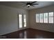 Bedroom featuring patio access, plantation shutters, and dark wood floors at 14376 W Desert Hills Dr, Surprise, AZ 85379