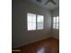 Bedroom featuring lovely shuttered windows and beautiful hardwood floors at 14376 W Desert Hills Dr, Surprise, AZ 85379