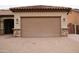 Attached garage with brick driveway, stone veneer, and house number visible above the door at 14376 W Desert Hills Dr, Surprise, AZ 85379