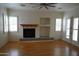Spacious living room with a fireplace, wood floors, and plantation shutters at 14376 W Desert Hills Dr, Surprise, AZ 85379