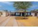 Charming blue home featuring white trim accents, a mature tree, and a driveway leading to a carport at 1622 N 17Th Ave, Phoenix, AZ 85007