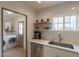 Bright kitchen area featuring modern stainless steel appliances, subway tile, and floating wood shelves at 1622 N 17Th Ave, Phoenix, AZ 85007