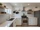 Well-lit kitchen with stainless steel appliances, floating shelves, and ample counter space at 1622 N 17Th Ave, Phoenix, AZ 85007