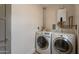 Functional laundry room with side-by-side washer and dryer units and a tankless water heater at 1622 N 17Th Ave, Phoenix, AZ 85007