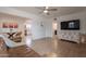 Bright living room flowing into dining and kitchen, featuring wood-look flooring, neutral paint, and leather couch at 1622 N 17Th Ave, Phoenix, AZ 85007
