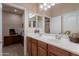 Double vanity bath with wood cabinets and entry to office and walk-in closet at 18226 W Stinson Dr, Surprise, AZ 85374