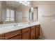Bathroom with double sinks, wood cabinets, neutral paint, and large mirrors at 18226 W Stinson Dr, Surprise, AZ 85374
