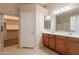 Main bathroom featuring double vanity, walk-in shower, and closet access at 18226 W Stinson Dr, Surprise, AZ 85374