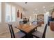Dining area with wood table and chairs, flooded with natural light from the large shuttered windows at 18226 W Stinson Dr, Surprise, AZ 85374