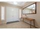 Inviting foyer with tile flooring, modern console table, decorative mirror, and double front doors, setting a welcoming tone at 18226 W Stinson Dr, Surprise, AZ 85374