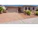 Attractive single-story home featuring a three-car garage, brick driveway, and desert landscaping at 18226 W Stinson Dr, Surprise, AZ 85374