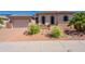 Charming single-story home featuring manicured landscaping, desert rock and a brick driveway at 18226 W Stinson Dr, Surprise, AZ 85374
