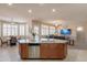 Bright kitchen with stainless steel dishwasher, central island, and an open view to the dining and living areas at 18226 W Stinson Dr, Surprise, AZ 85374