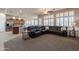 Open-concept living room with plush carpeting, natural light, and a spacious black leather sectional sofa at 18226 W Stinson Dr, Surprise, AZ 85374