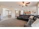 Spacious living room featuring large sectional, ceiling fan, and open floor plan leading to kitchen and breakfast area at 18226 W Stinson Dr, Surprise, AZ 85374