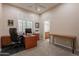 Home office with built-in desk, executive chair, carpet, and plantation shutters at 18226 W Stinson Dr, Surprise, AZ 85374